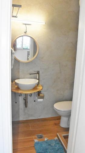 a bathroom with a sink and a toilet and a mirror at MNS Marvelous Nirvana Seascape, Creativity in Perani