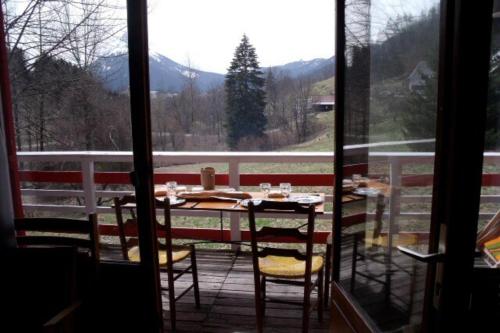 une table et des chaises sur un balcon avec vue sur une montagne dans l'établissement Grand chalet vue montagne, à Saint-Pierre-de-Chartreuse