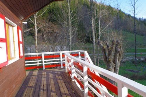 une terrasse couverte d'une maison avec une clôture blanche dans l'établissement Grand chalet vue montagne, à Saint-Pierre-de-Chartreuse