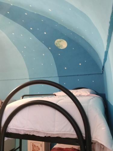 a bed in a room with a moon and stars on the ceiling at Silenzio e Buio in Calizzano
