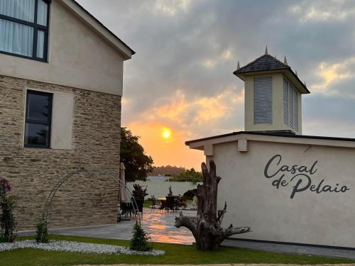 a building with the sunset in the background at Casal de pelaio in Barreiros
