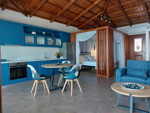 a kitchen and living room with blue cabinets and tables at Horizon Studios with Sea View - Free Parking in Glossa