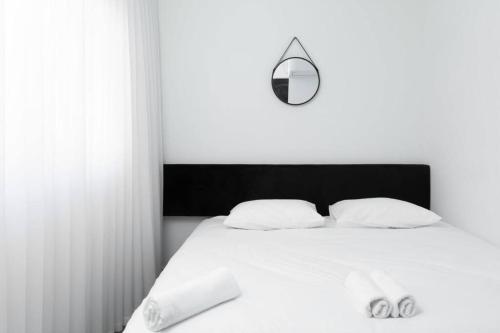 By Eezy - דירת נופש עם חדר שינה אחד במיקום מעולה Ashram 3 في إيلات: غرفة نوم مع سرير أبيض مع اللوح الأمامي الأسود