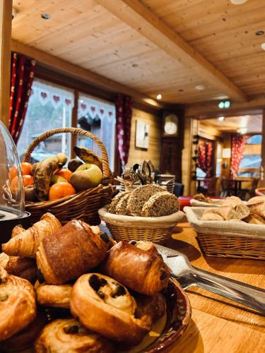 a table with baskets of bread and pastries on it at Hameau des Prodains - Résidence in Morzine