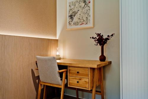 a wooden desk with a vase of flowers on it at Apartamenty Wydma & Las BlueApart in Jastarnia