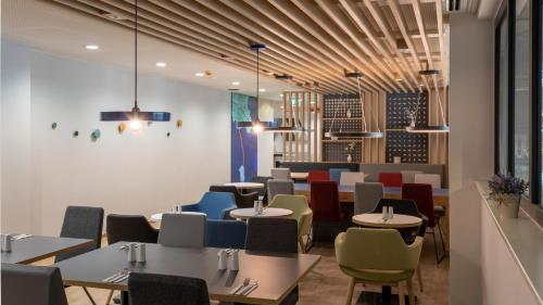 a dining room with tables and chairs at Holiday Inn Express - Hamburg South A7-AS42 by IHG in Egestorf