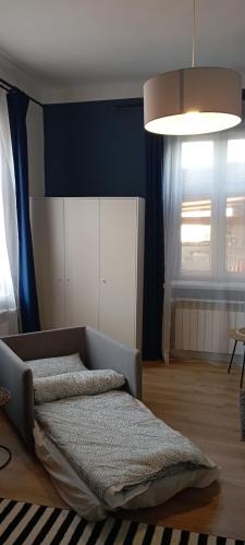 - un salon avec un lit et un mur bleu dans l'établissement Błękitne Studio, à Żywiec