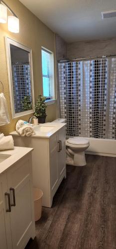une salle de bain avec un lavabo et des toilettes et des fenêtres dans l'établissement The Cozy Corner House at Haltom City Texas, à Haltom City