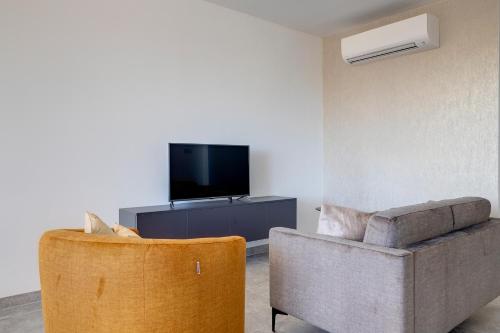 a living room with a couch and a tv at Valley's Edge Apartments in San Ġwann