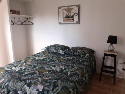 1 dormitorio con 1 cama con manta y taburete en F1 proche mer, en Saint-Nazaire