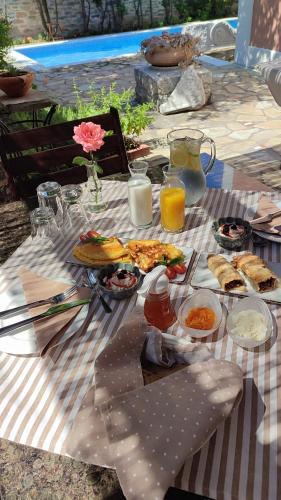 a picnic table with plates of food and drinks at Αρχοντικό Ταξίμι (Μουντζουρίδη) in Argalasti