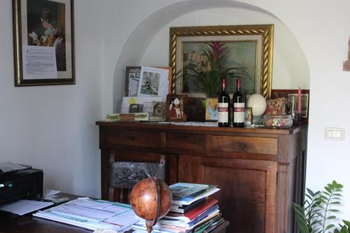 Habitación con mesa con libros y botellas de vino en Agriturismo Il Poggiolo, en Montemerano