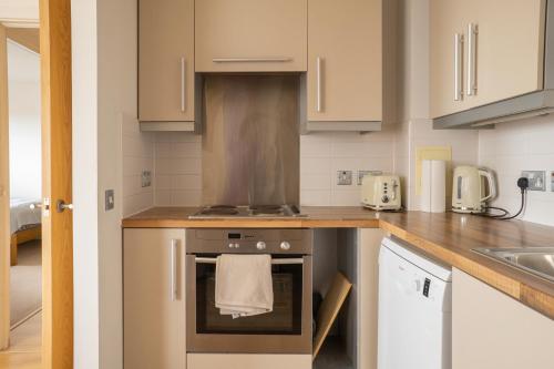 a kitchen with a stove top oven next to a sink at City Air Apartments - SHADWELL - GREAT TRANSPORT LINKS in London