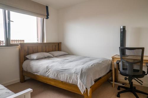 a bedroom with a bed and a desk and a chair at City Air Apartments - SHADWELL - GREAT TRANSPORT LINKS in London