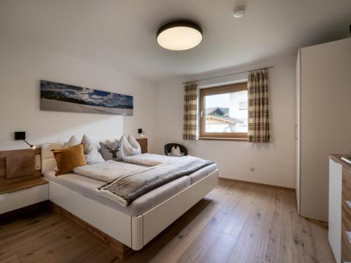 a bedroom with a bed and a window at Bergpanorama Kössen in Kössen