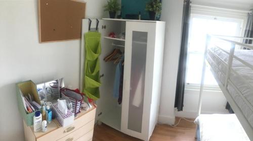 ein Zimmer mit einem weißen Kühlschrank in einem Schlafzimmer in der Unterkunft Quaint Edwardian Cottage in London