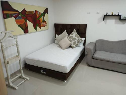 Camera con letto, divano e sedia di Loft precioso en San Mateo envigado a Envigado