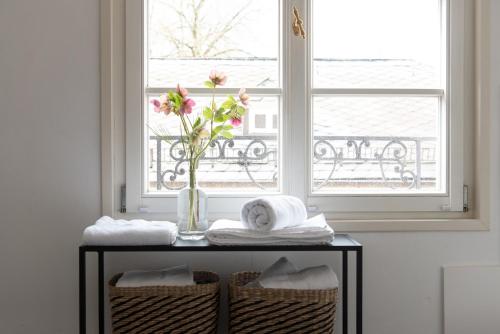 a table with a vase of flowers on it in front of a window at Palais Wunderlich in Lahr