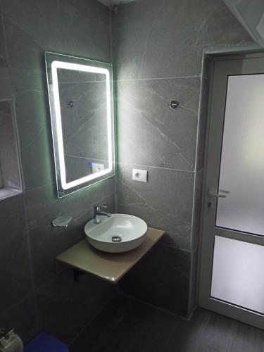W łazience znajduje się umywalka, lustro i prysznic. w obiekcie Kristina Mitllari 2 w mieście Pogradec