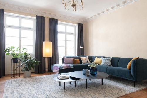 ein Wohnzimmer mit einem blauen Sofa und einem Tisch in der Unterkunft Palais Wunderlich in Lahr