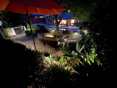 a backyard with an umbrella and a pool at night at Villa La Reforma - Newly Designed 4BR HOUSE & POOL in Los Angeles by Topanga in Los Angeles