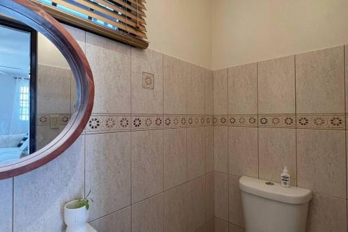 uma casa de banho com um WC e um espelho. em Bella Casita Ayala- Zapata em Cabo Rojo