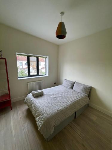 um quarto com uma cama e uma janela em Contemporary 3 bed house with spacious garden close to Stratford & Canary Wharf em Londres
