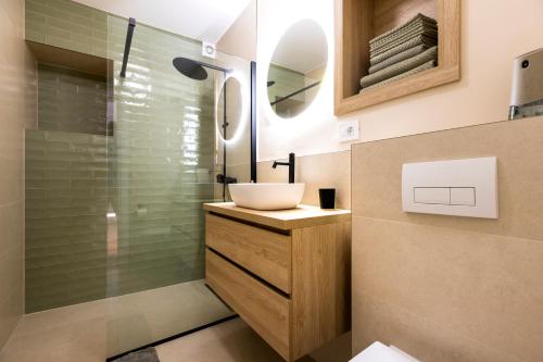 a bathroom with a sink and a glass shower at Sidrina in Mali Lošinj