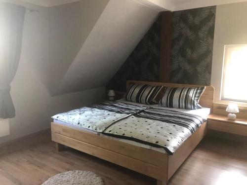 a bedroom with a bed with a wooden headboard and a window at Ferienwohnung zum Tiefenthal 