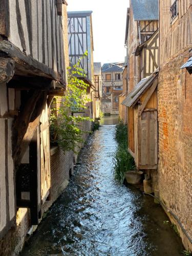 a small canal in a city with buildings at Chambres et Table d'Hôtes du Coquerel in Saint-Siméon