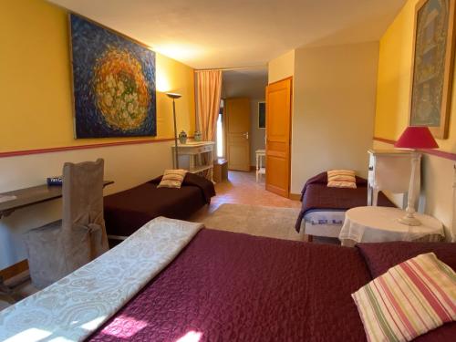 a living room with two beds and a painting on the wall at Chambres et Table d'Hôtes du Coquerel in Saint-Siméon