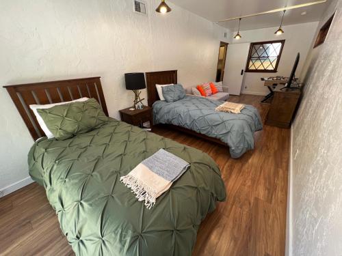 two beds in a room with wood floors at Villa La Reforma - Newly Designed 4BR HOUSE & POOL in Los Angeles by Topanga in Los Angeles