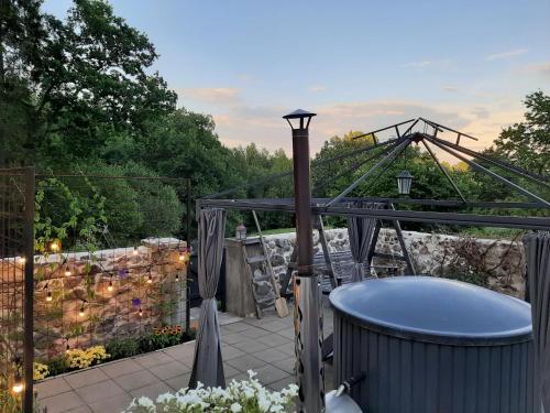 d'une baignoire sur la terrasse avec jardin. dans l'établissement Mellene 1 bedroom house in nature & hot tube, à Turaida