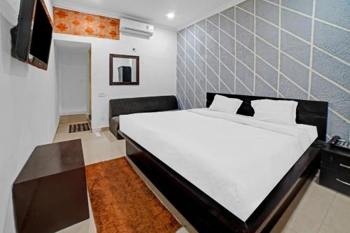 A bed or beds in a room at Capital O Convivial Hotel Amit Regency