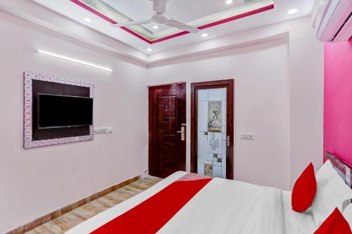 a bedroom with a bed and a flat screen tv at Super OYO The Prima Residency in Ghaziabad