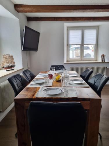 una gran mesa de madera con sillas en una habitación en Stylish large 4 room apartment close to the center en Grenzach-Wyhlen