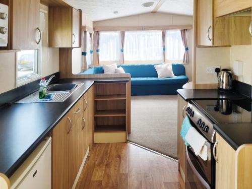 eine Küche und ein Wohnzimmer in einem Wohnwagen in der Unterkunft The Burrow - 152 Mallard Lake in South Cerney