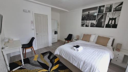 a bedroom with a bed and a desk and chairs at Deluxe Double bedroom with private bathroom, parking and WiFi in Leeds