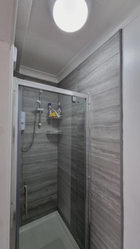 y baño con ducha y puerta de cristal. en Deluxe Double bedroom with private bathroom, parking and WiFi en Leeds