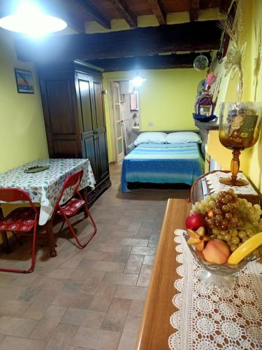 una camera con letto e tavolo con un cesto di frutta di La Fontanella a Castagneto Carducci
