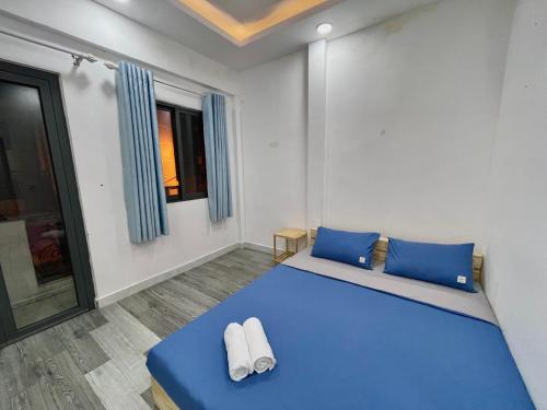 een slaapkamer met een groot blauw bed met blauwe kussens bij Enjoy Homestay in Ho Chi Minh-stad