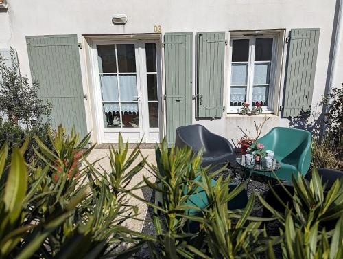 deux chaises et une table devant une maison dans l'établissement Maison BARBADINE, à Saint-Denis-dʼOléron