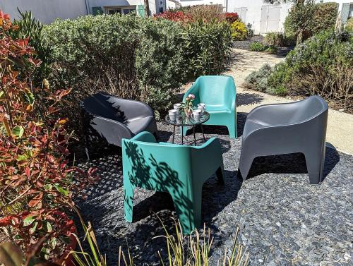 un groupe de chaises et une table dans une cour dans l'établissement Maison BARBADINE, à Saint-Denis-dʼOléron