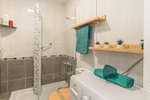 a bathroom with a shower and a washing machine at ABC - Apartment Beach & City + Balcony 6m2 in Las Palmas de Gran Canaria
