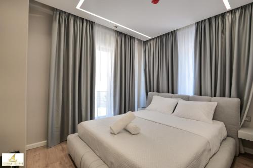 1 dormitorio con 1 cama blanca grande frente a una ventana en NORGE HOTEL, en Ksamil
