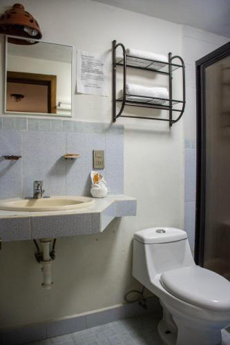 a bathroom with a sink and a toilet and a mirror at Hotel Real del Carmen - Ideal para familias y parejas in San Cristóbal de Las Casas