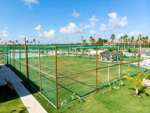 einen Volleyballplatz in einem Park mit Palmen in der Unterkunft Muro Alto Condomínio Clube in Porto De Galinhas