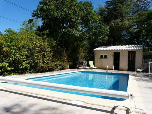 une piscine avec une maison en arrière-plan dans l'établissement agréable mas au calme jusqu'à 11 pers. près d'Uzès, à Saint-Laurent-la-Vernède