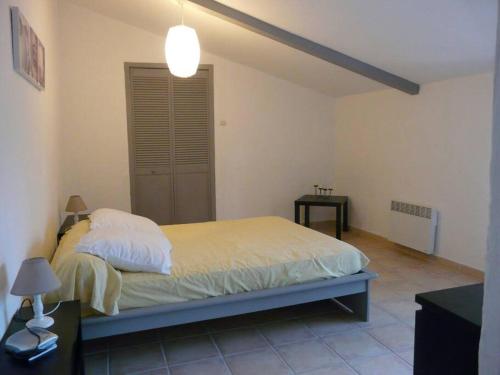 a bedroom with a bed and two tables and a lamp at agréable mas au calme jusqu'à 11 pers. près d'Uzès in Saint-Laurent-la-Vernède