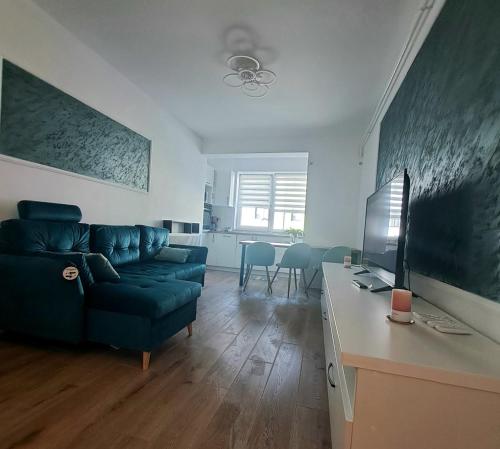 a living room with a blue couch and a table at Imperium Residence in Sfîntu Ilie